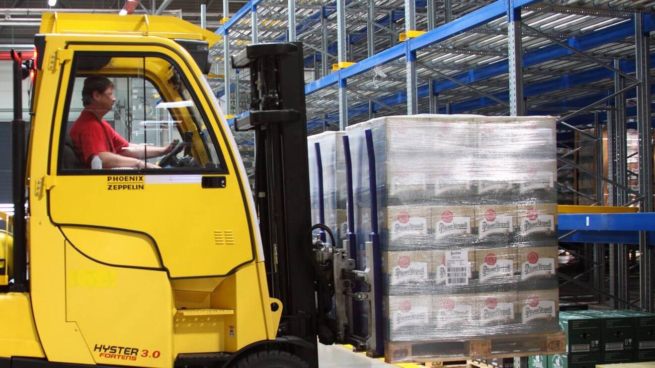 Ein Lagerarbeiter der mit Hilfe eines Flurförderzeugs eine Palette aus einem BITO Palettendurchlaufregal entnimmt