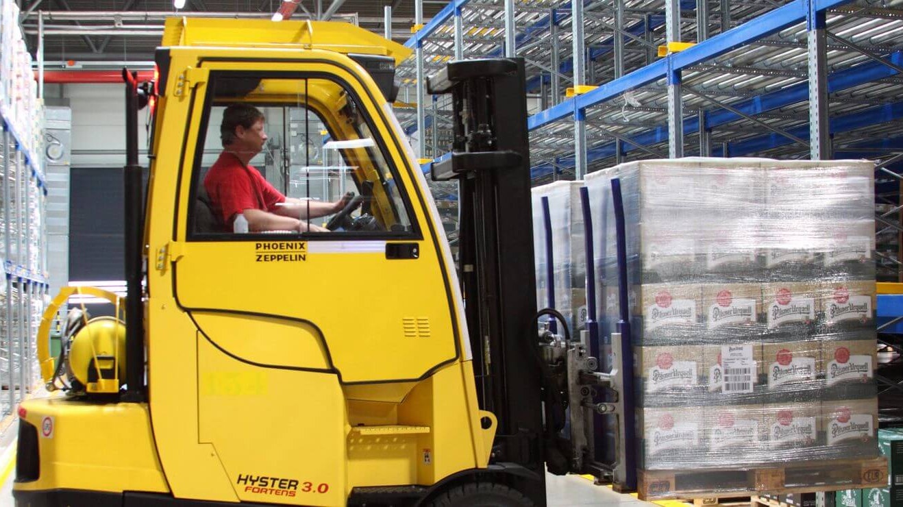 Ein Lagerarbeiter der mit Hilfe eines Flurförderzeugs eine Palette aus einem BITO Palettendurchlaufregal entnimmt