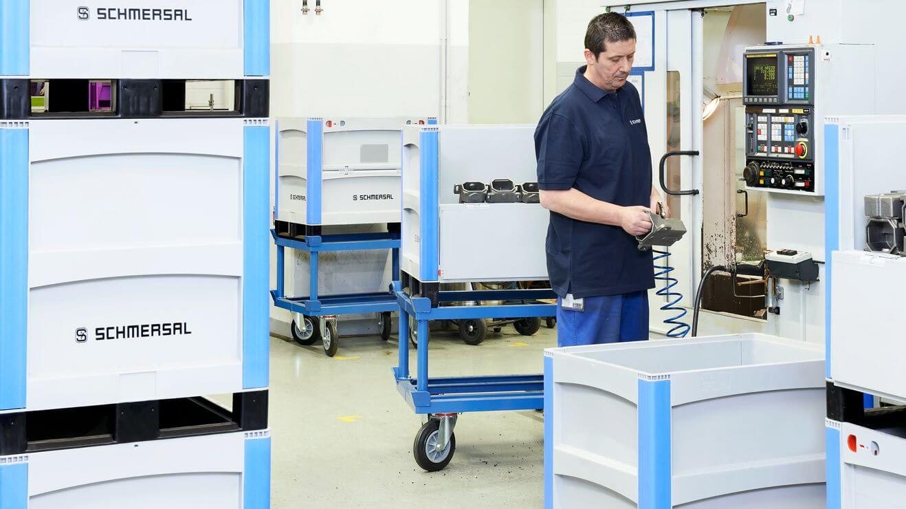 Ein Arbeiter legt Metallteile in BITO Schwerlastbehälter SL