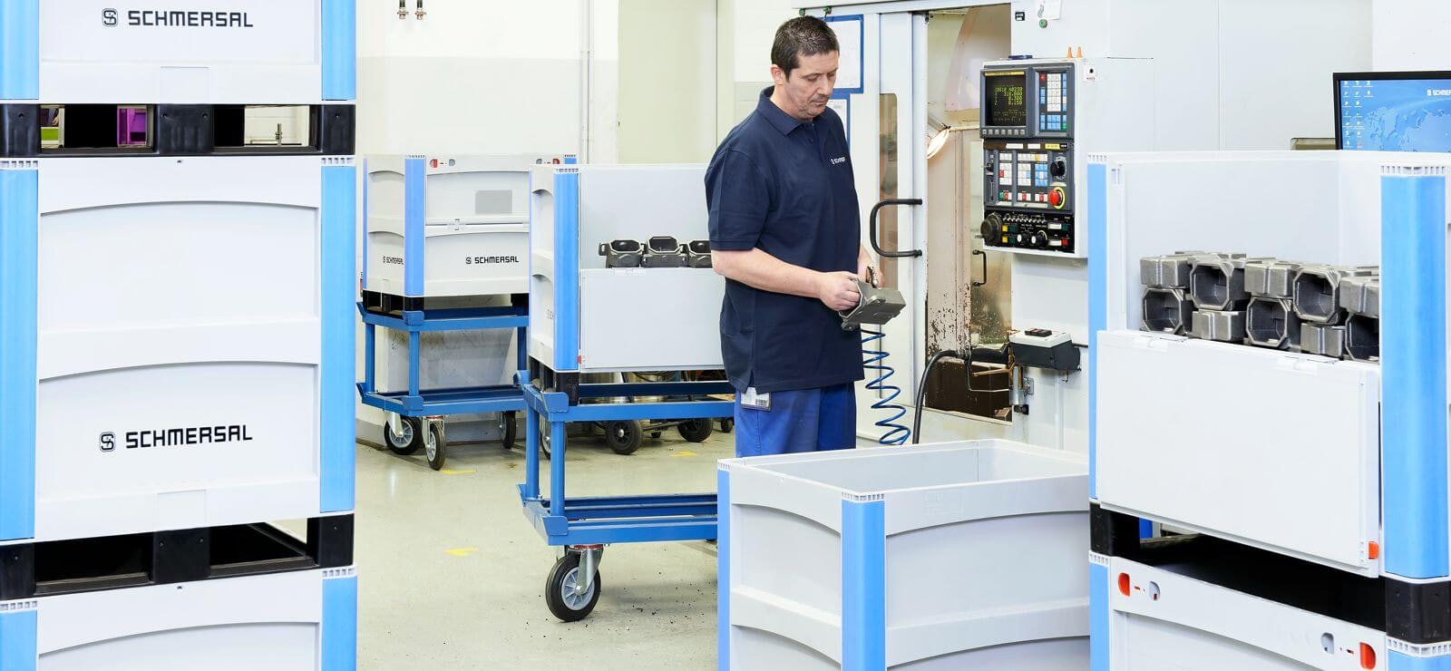 Ein Arbeiter legt Metallteile in BITO Schwerlastbehälter SL