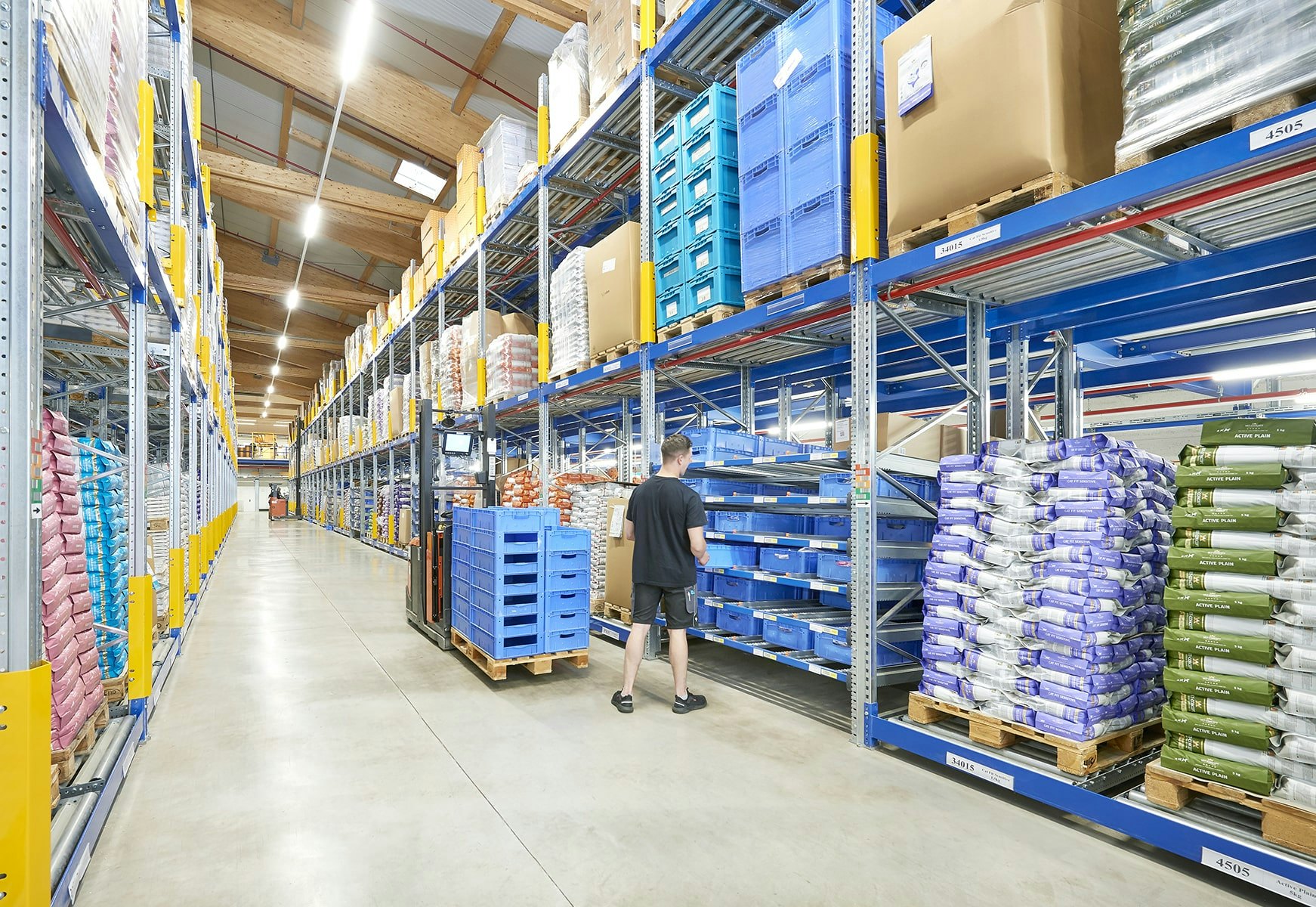 Ein Lagerarbeiter an einem BITO Durchlaufregal und BITO Palettendurchlaufregal