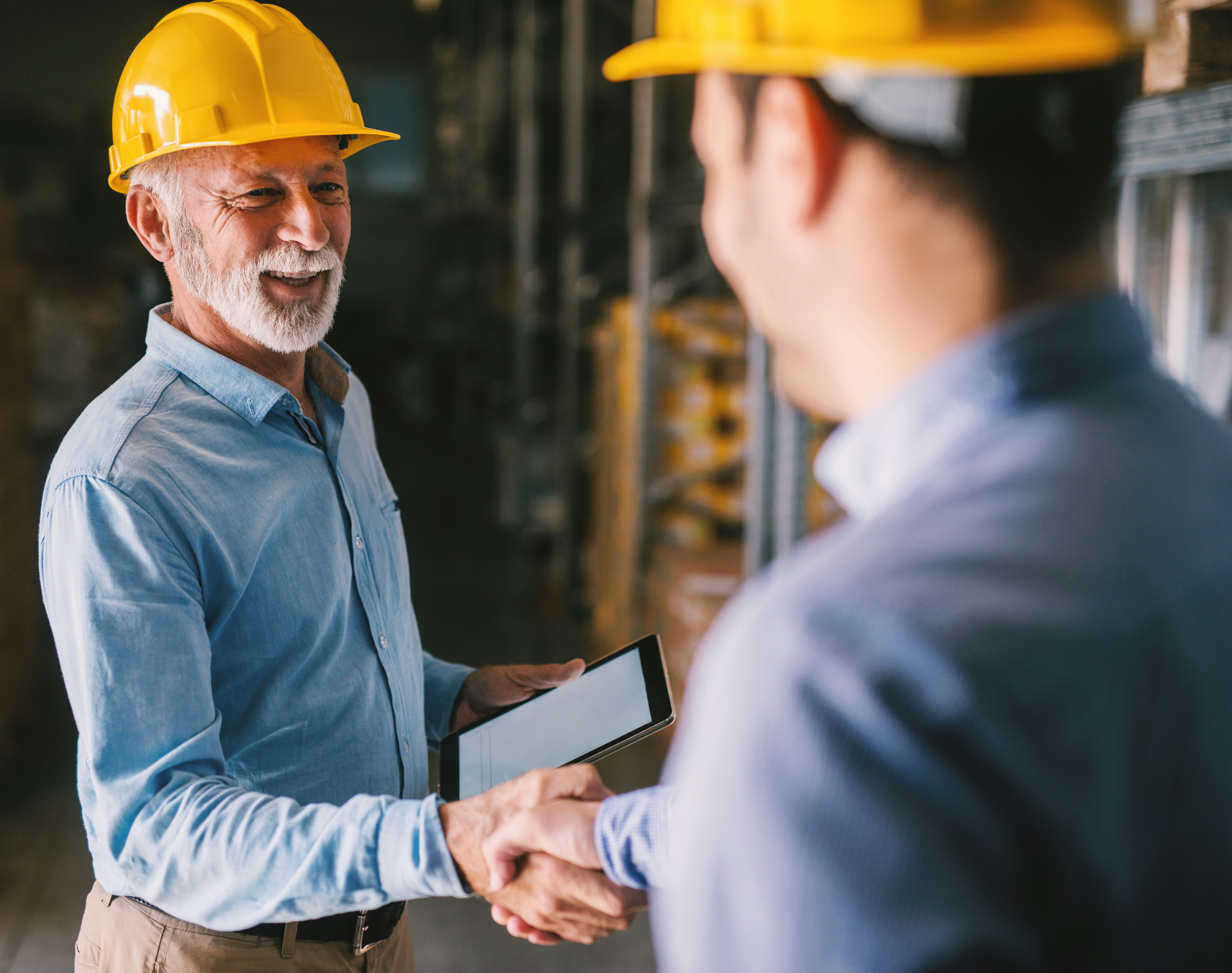 Zwei Männer mit Schutzhelmen beim Handshake