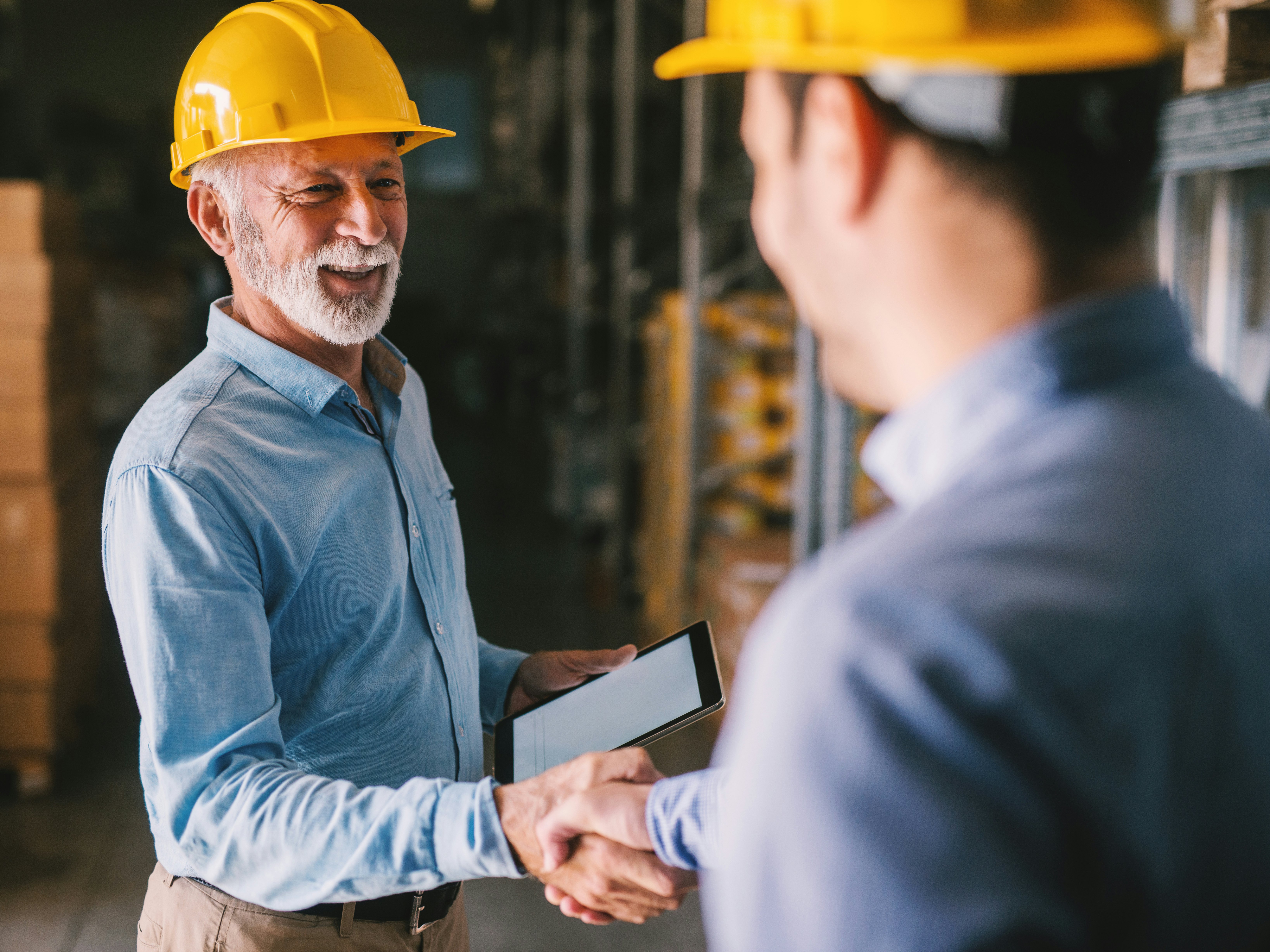 Zwei Männer mit Schutzhelmen beim Handshake