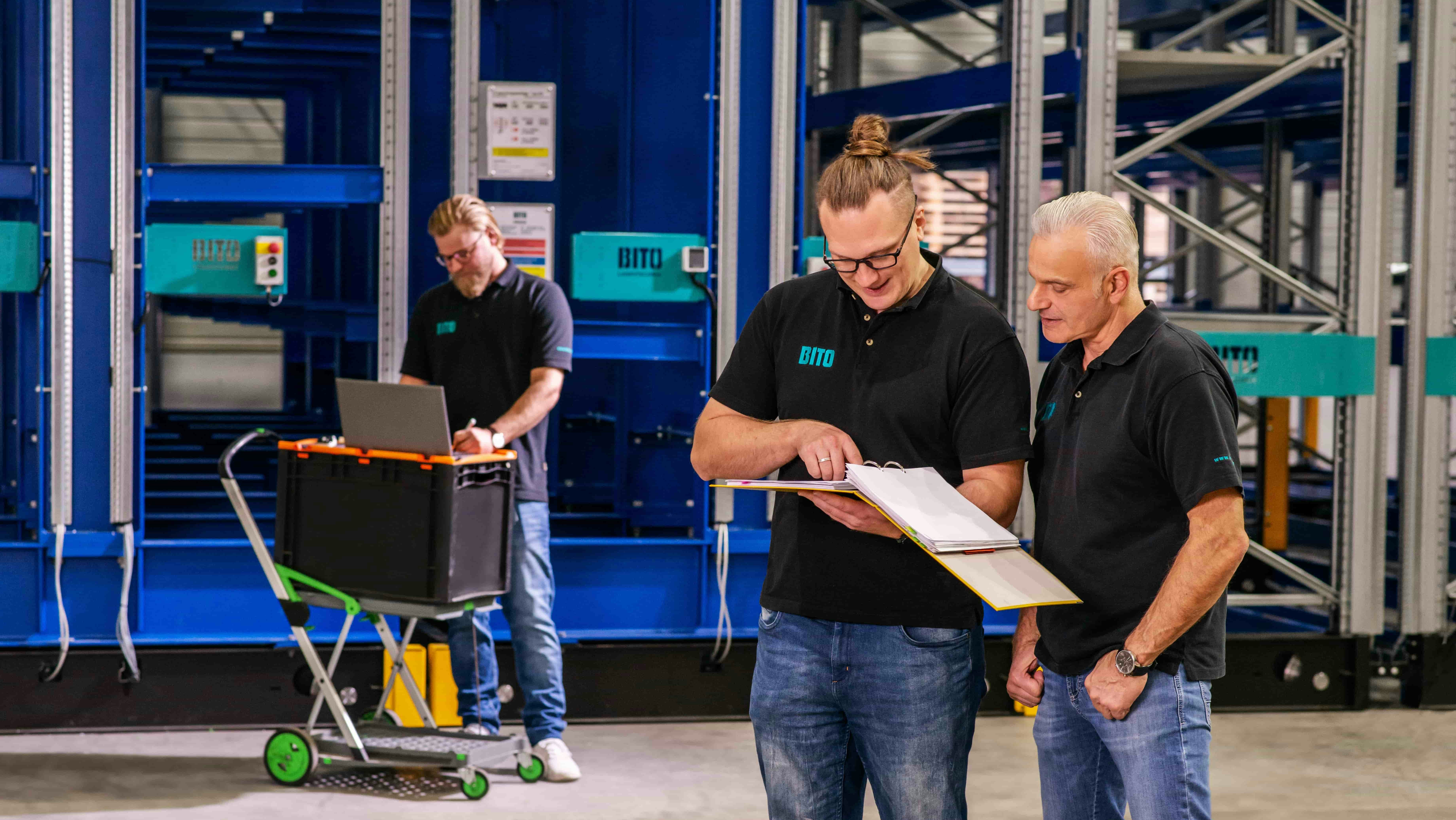 Drei Männer bei der Inspektion einer Regalanlage