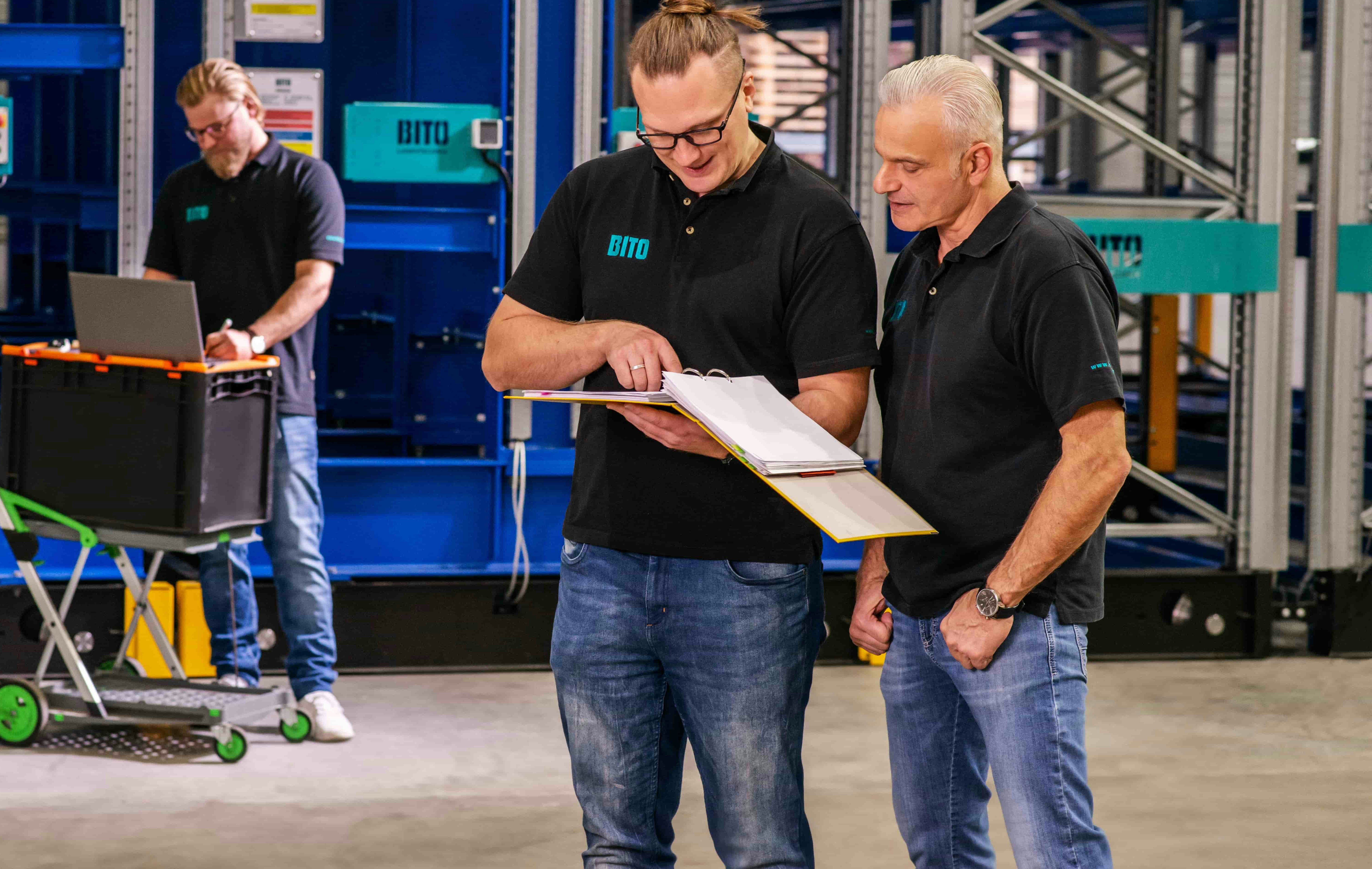Drei Männer bei der Inspektion einer Regalanlage
