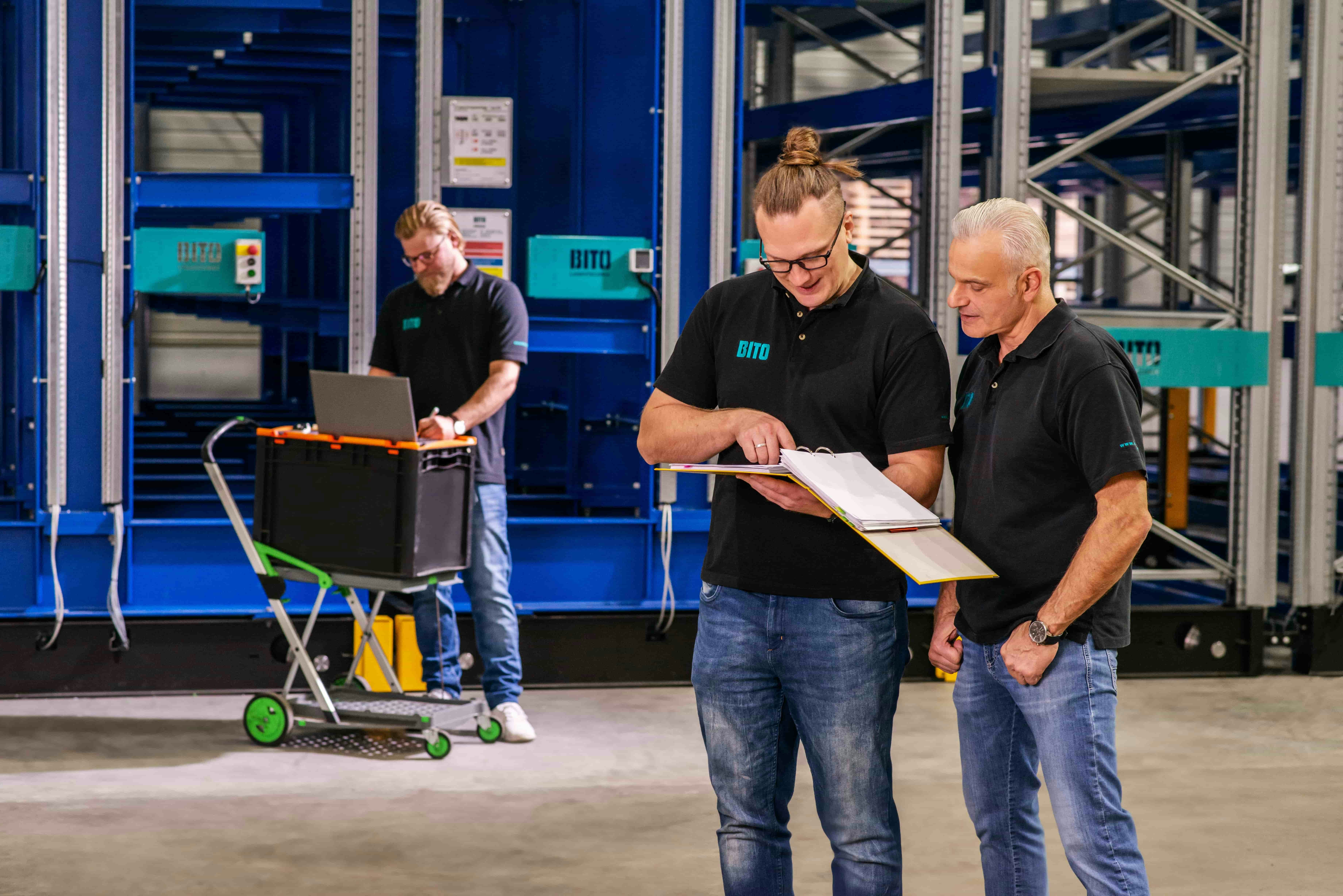 Drei Männer bei der Inspektion einer Regalanlage
