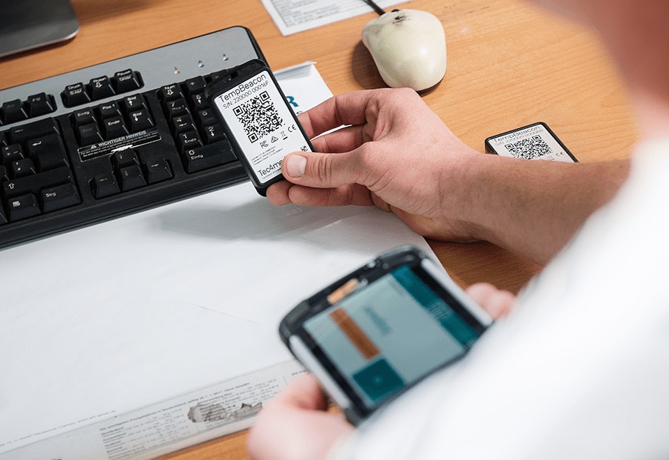 SmartHub Alkaline Batterie Person nutzt ein Smartphone und einen Laptop gleichzeitig zur Verwaltung von Daten