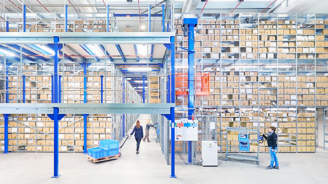 Ein Arbeiter verlädt gerade eine Palette in einer großen Lagerhalle