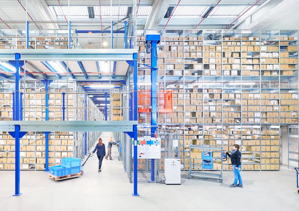 Ein Arbeiter verlädt gerade eine Palette in einer großen Lagerhalle