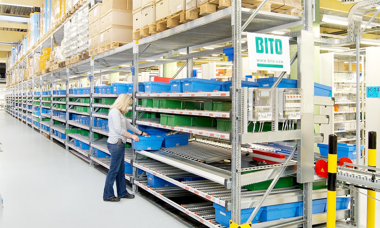 Eine Frau schiebt einen BITO Behälter in ein BITO Palettenregal.