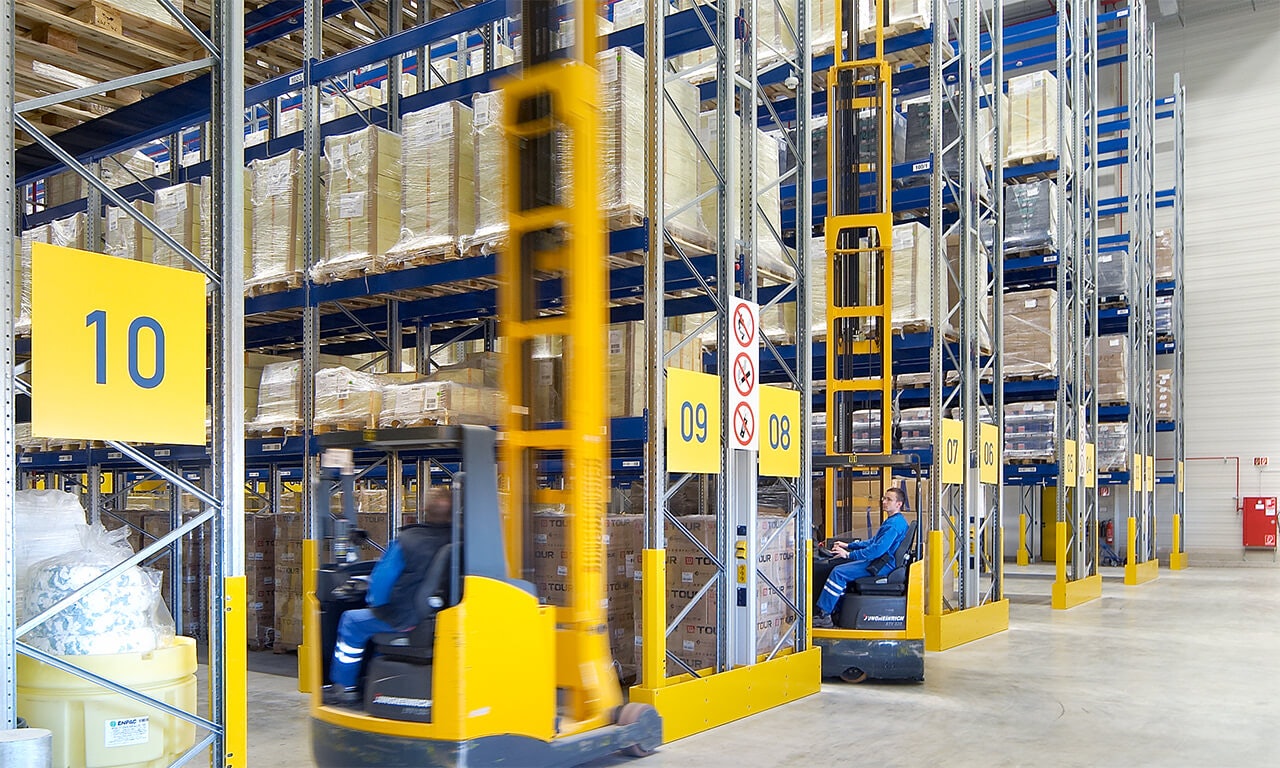 Große und unhandliche Artikel Die Stapler fahren zwischen den Palettenregalen hin und her.