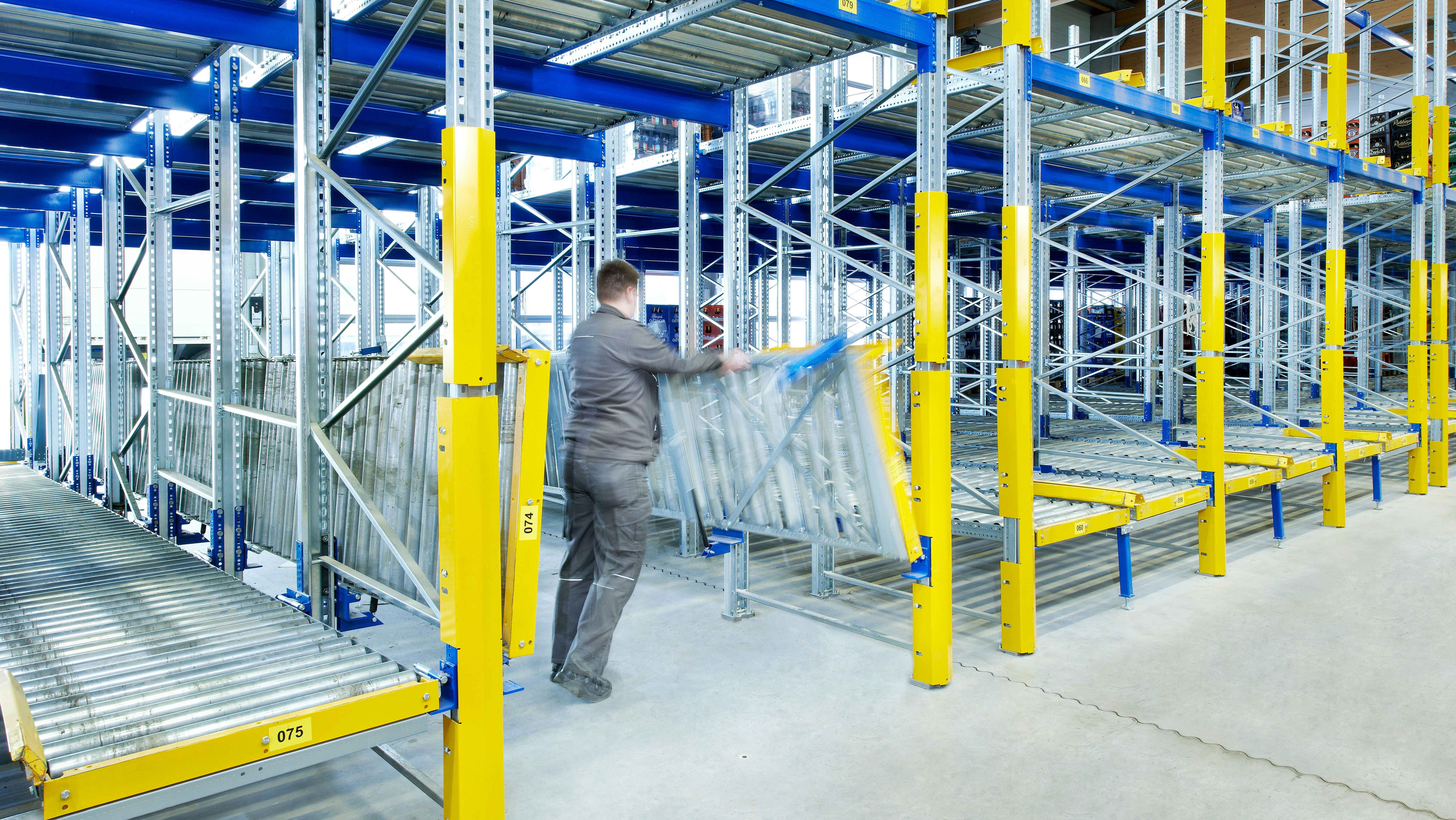Ein Mann klappt die Rollleisten eines BITO Regals ein.
