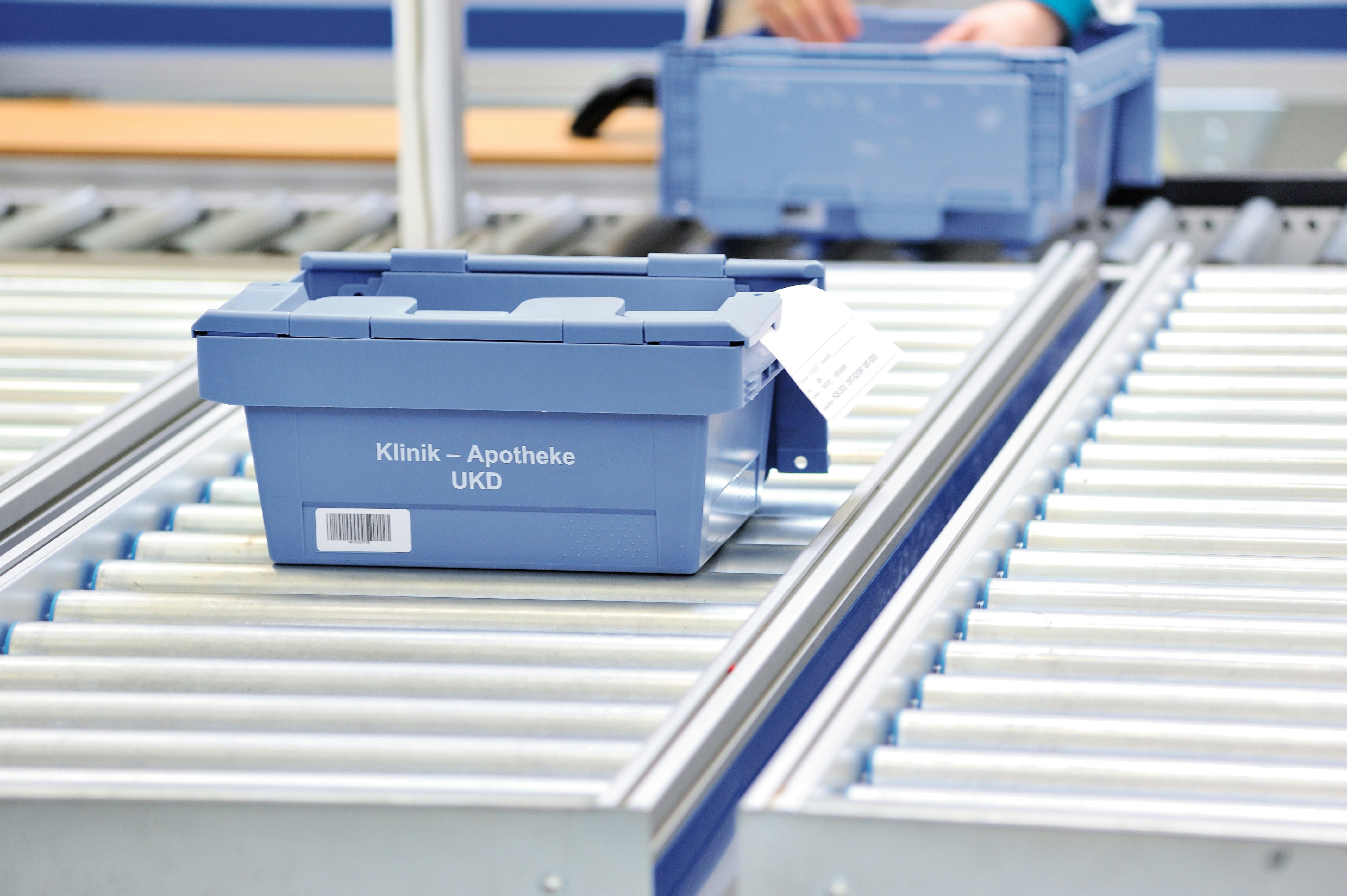 Ein BITO Behälter für die Klinik und Apotheke steht auf einer BITO Rollenbahn.