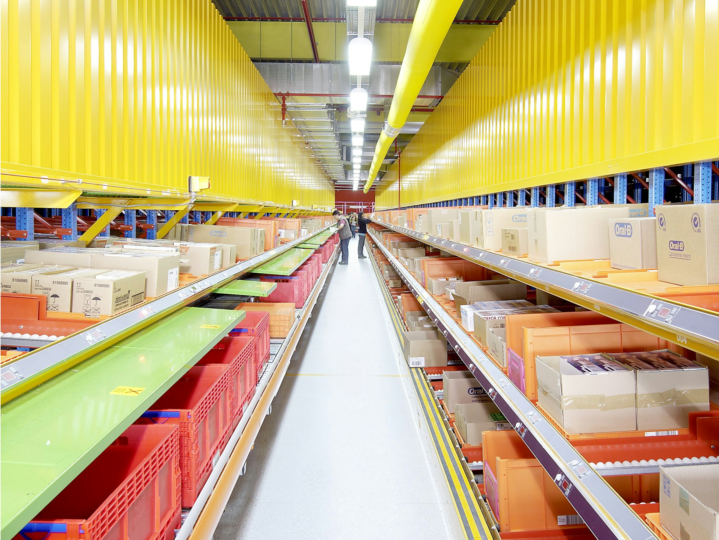 BITO Genomloppsställ för styckegods Zwei Stückgutdurchlaufregale rechts und links sind in der Mitte durch eine langen Gang voneinander getrennt.