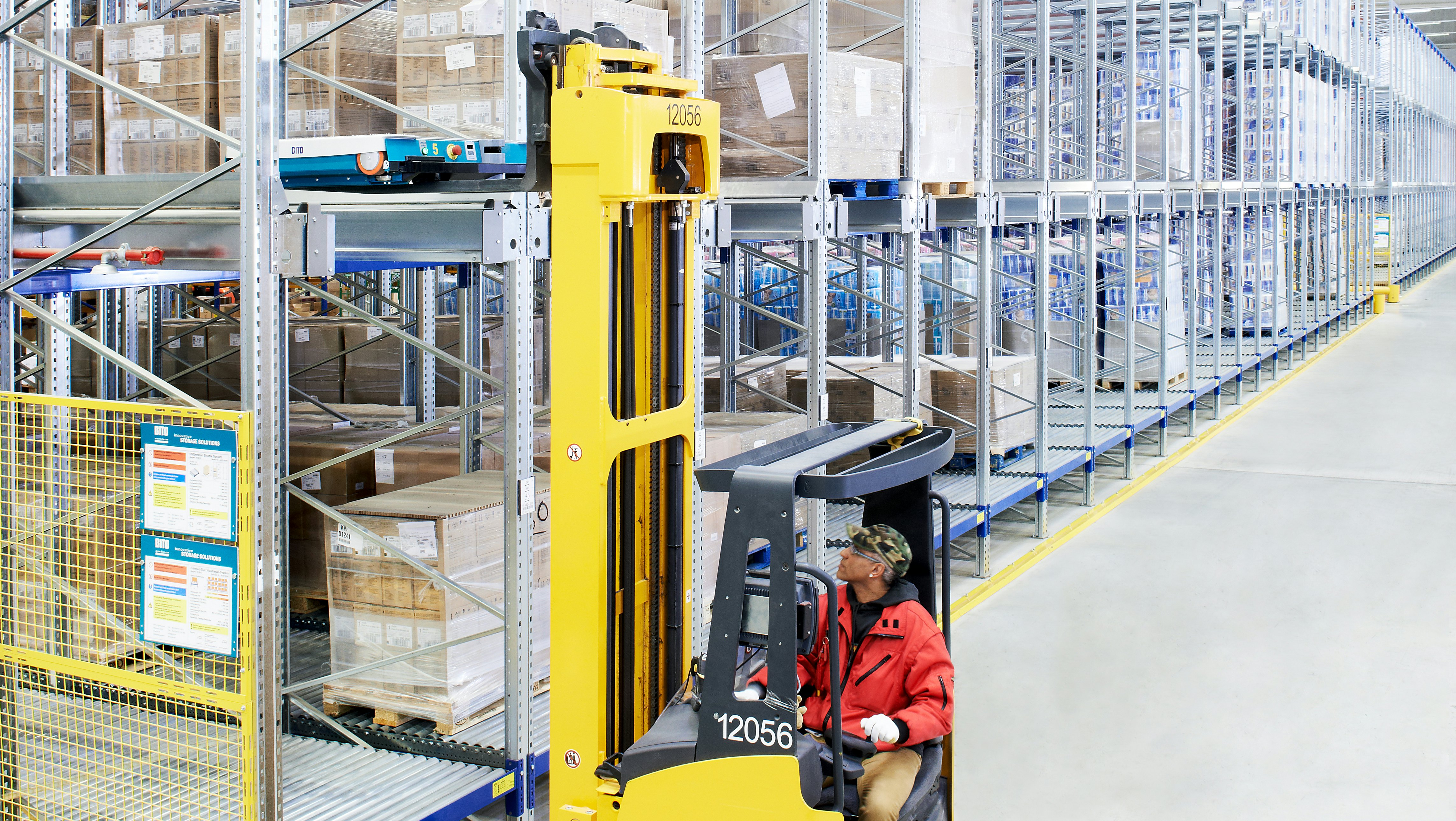 BITO Paletten-Durchlaufregallager kombiniert mit einem Shuttle-Kompaktlager Ein Mann holt mit dem Stapler eine Palette aus einem BITO Lagerregal.