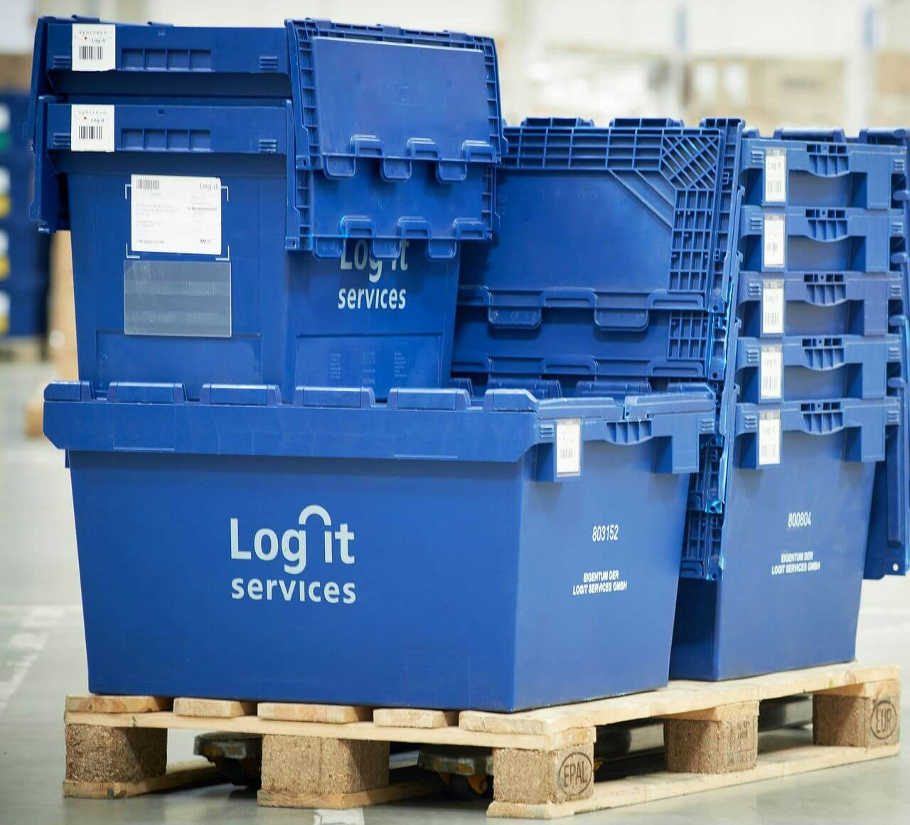 Pojemniki transportowe MB BITO Behälter in verschiedenen Größen mit der Aufschrift Log it Services sind auf einer Palette gestapelt.