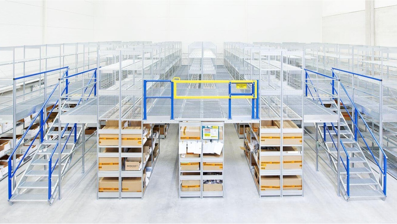 BITO Multi-tier installations Ein BITO Regal, das in der ersten Etage mit Paketen gefüllt ist. Eine Treppe führt zur zweiten Etage, die allerdings noch leer ist.