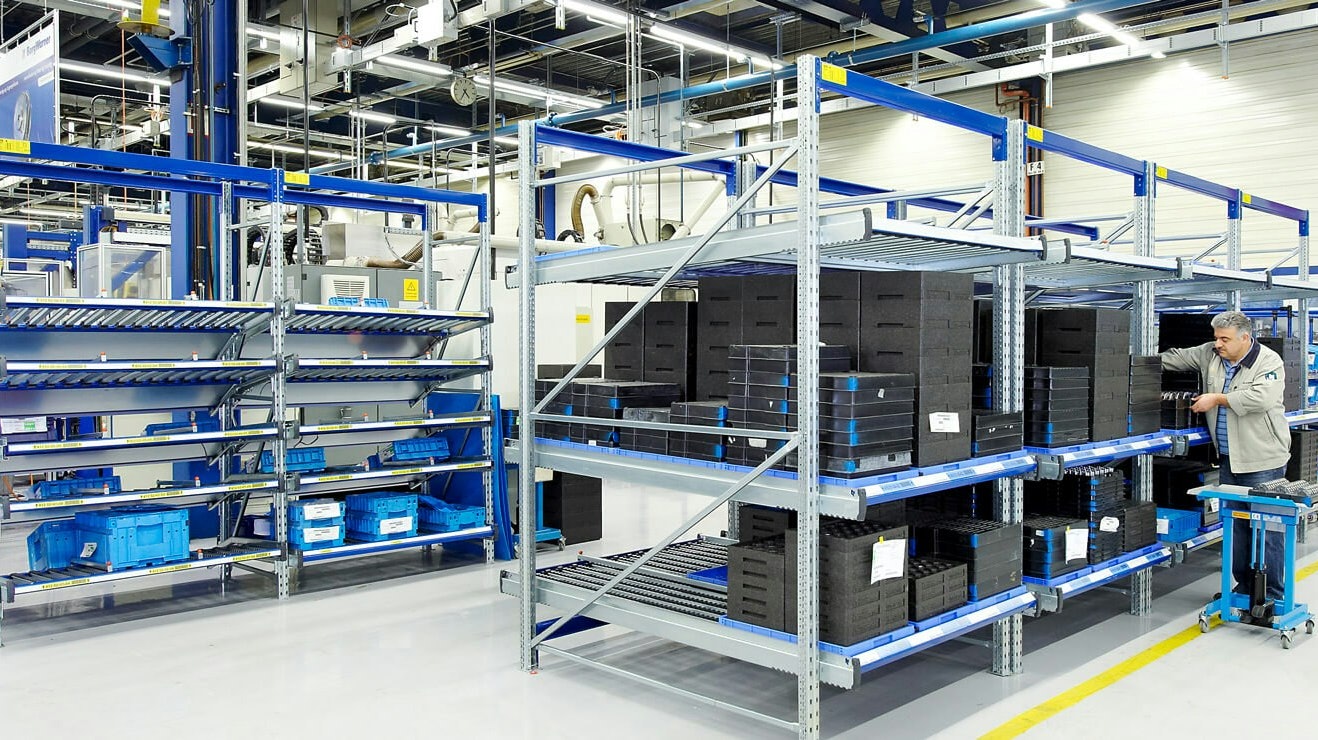 BITO Carton live storage racking Ein BITO Regal in einer Halle, welches mit Kisten gefüllt ist. Ein Mann hebt eine Kiste heraus.