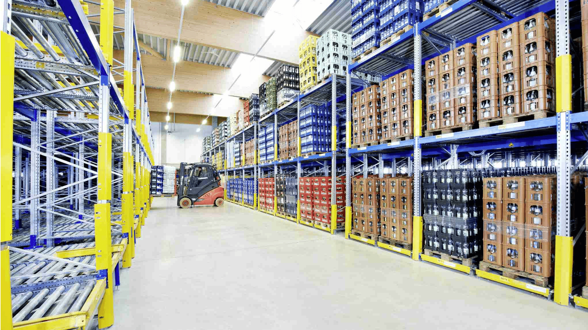 Getränke werden in einem BITO Regal gelagert. Ein Stapler lädt eine Palette mit Getränken in das Regal ein.