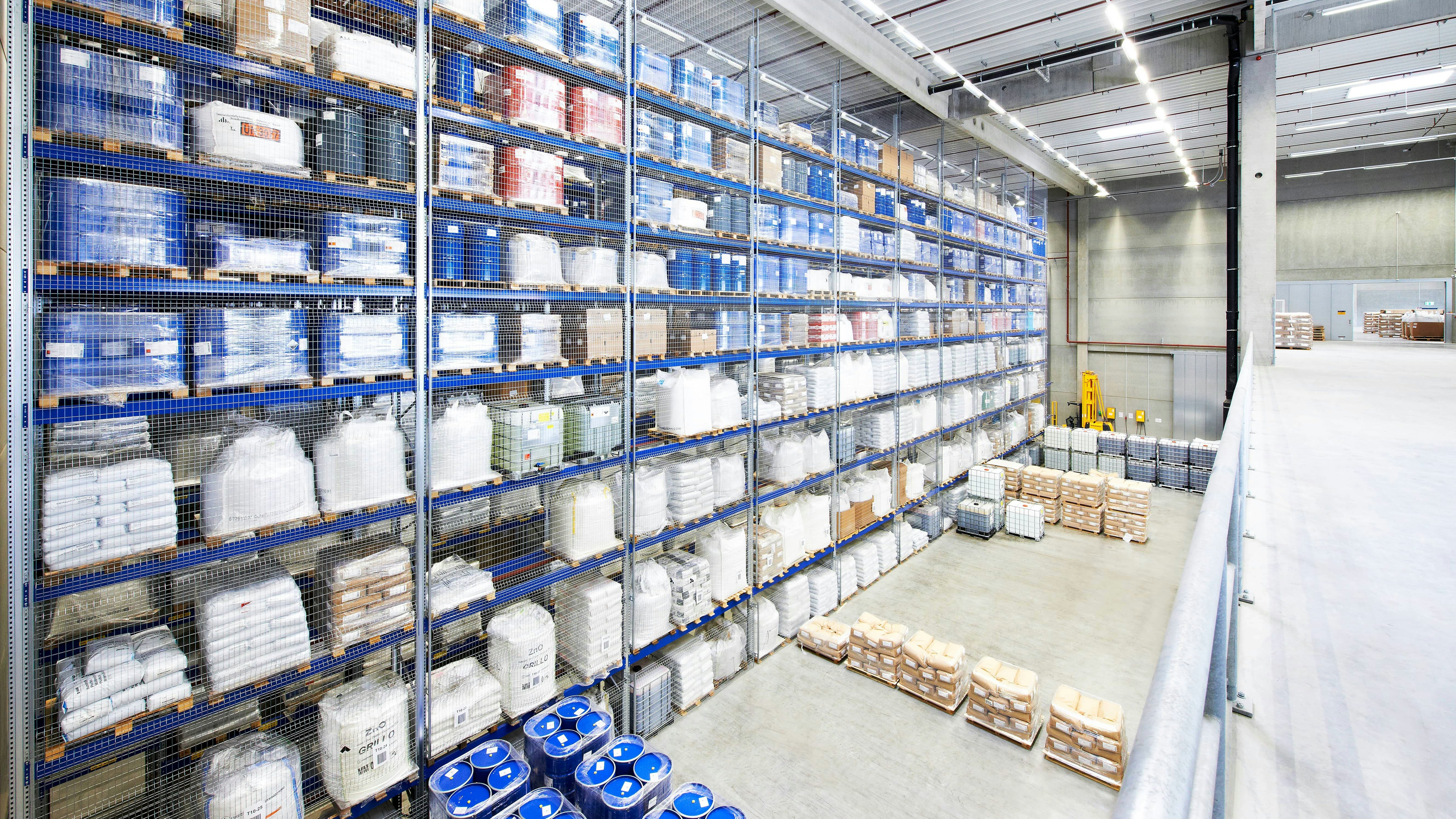 BITO Palettendurchlaufregal Ein volles BITO Lagerregal von hinten. Paletten mit Produkten stehen davor auf dem Boden.