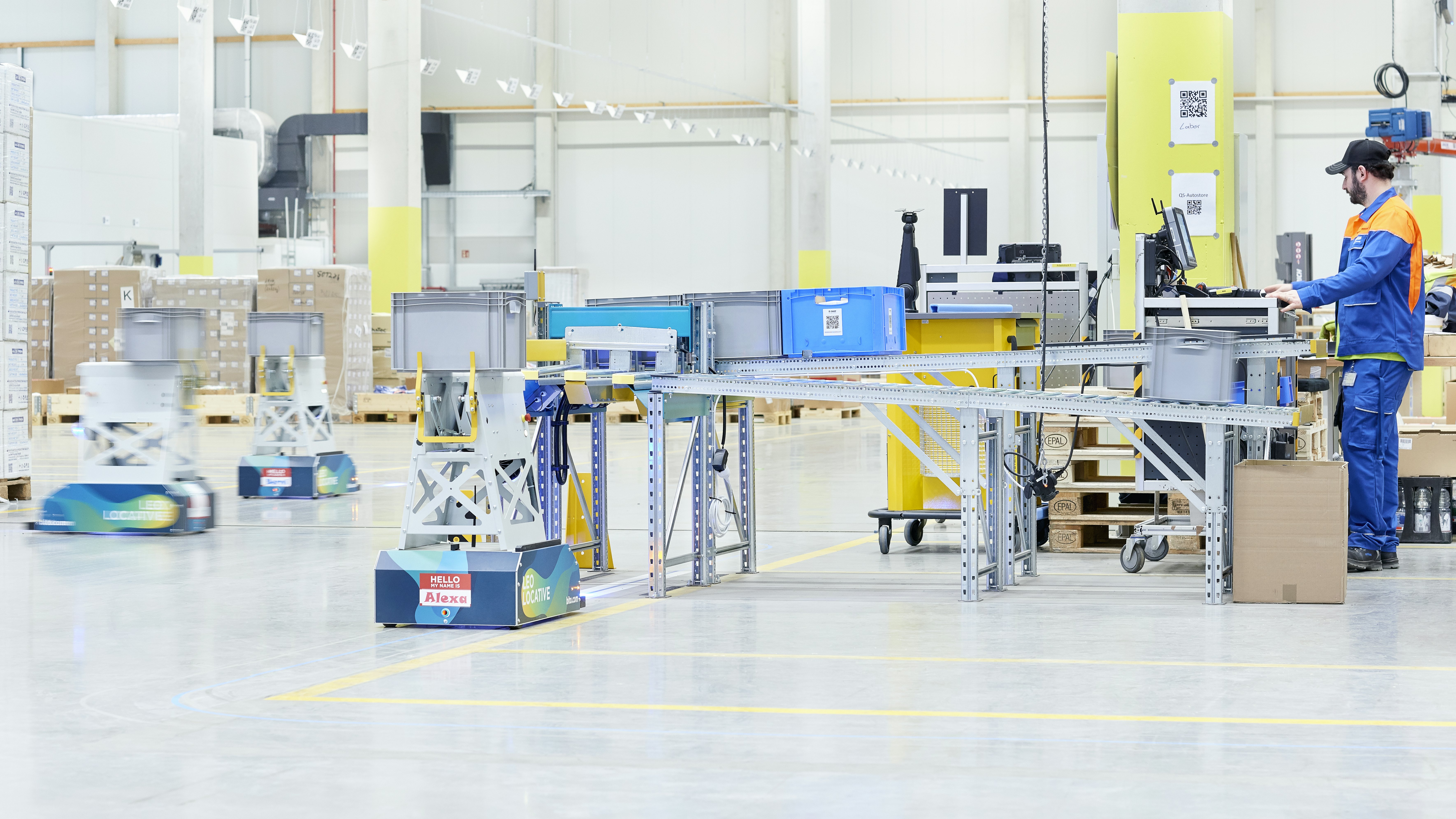 Véhicules à guidage automatique BITO LEO Eine Lagerhalle, in der mehrere LEO Locative BITO Behälter transportieren.