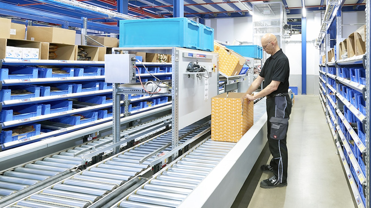 Bacs gerbables norme Europe et pistes à rouleaux Ein Mann steht in der Mitte zwischen zwei BITO Lagerregalen samt BITO Behältern. Er packt Kisten, die auf Rollleisten weiter transportiert werden.