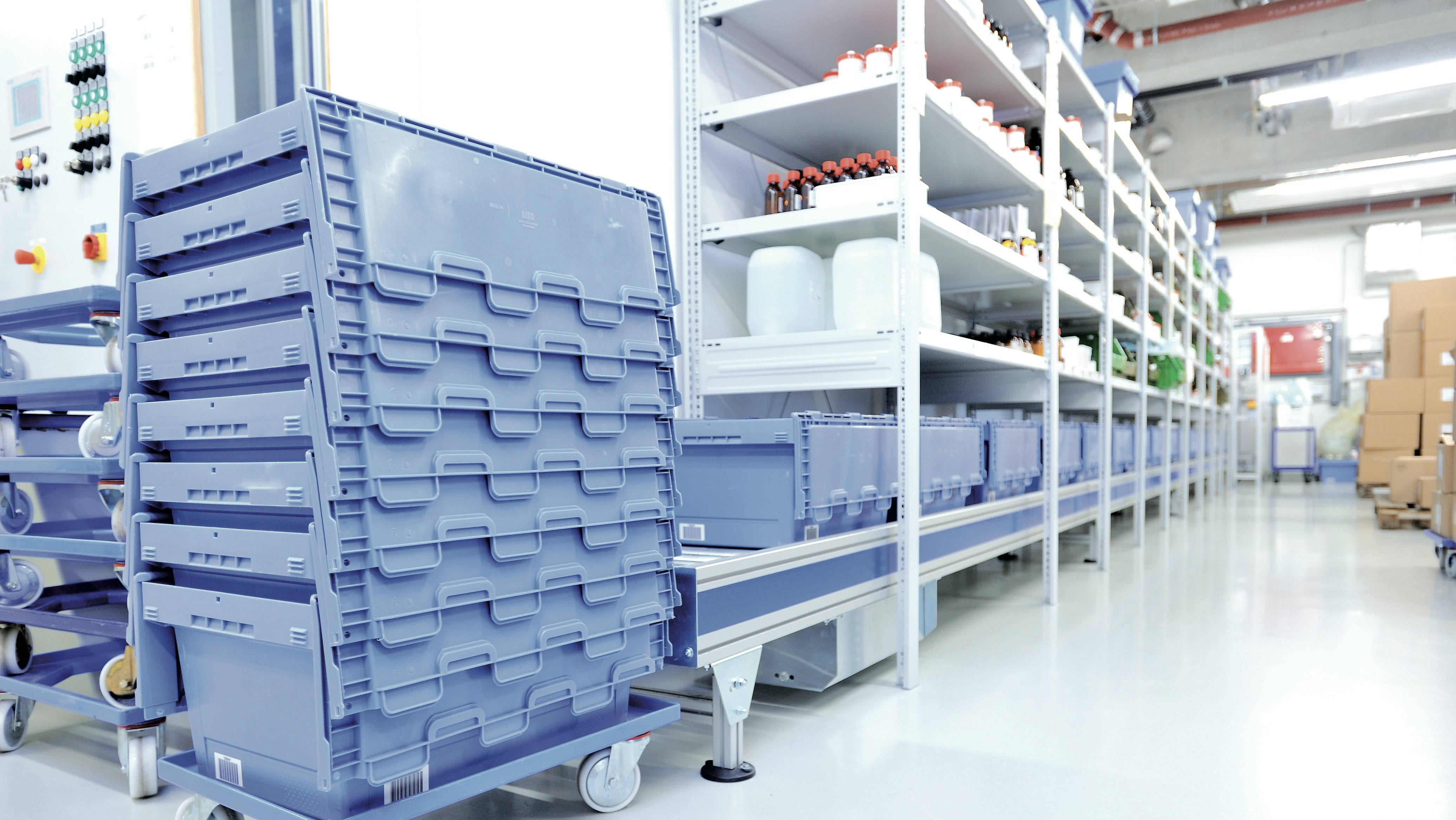 BITO Mehrwegbehälter MB & Fachbodenregal Eine Rollleiste führt unter dem Medikamentenregal entlang. Auf ihr stehen BITO Behälter , die am Ende der Rollleiste gestapelt werden.