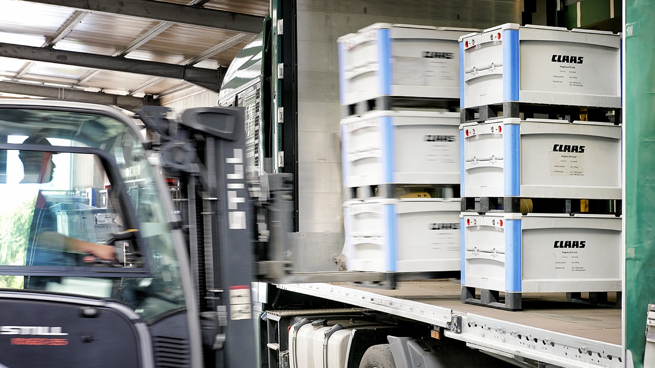 BITO SL 86 Behälter Ein Stapler verlädt gestapelte BITO Behälter, mit der Aufschrift Claas, auf einen LKW.