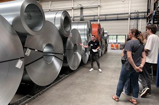 Große Metallrollen in der BITO Werkhalle mit engagierten Auszubildenden und Betreuern