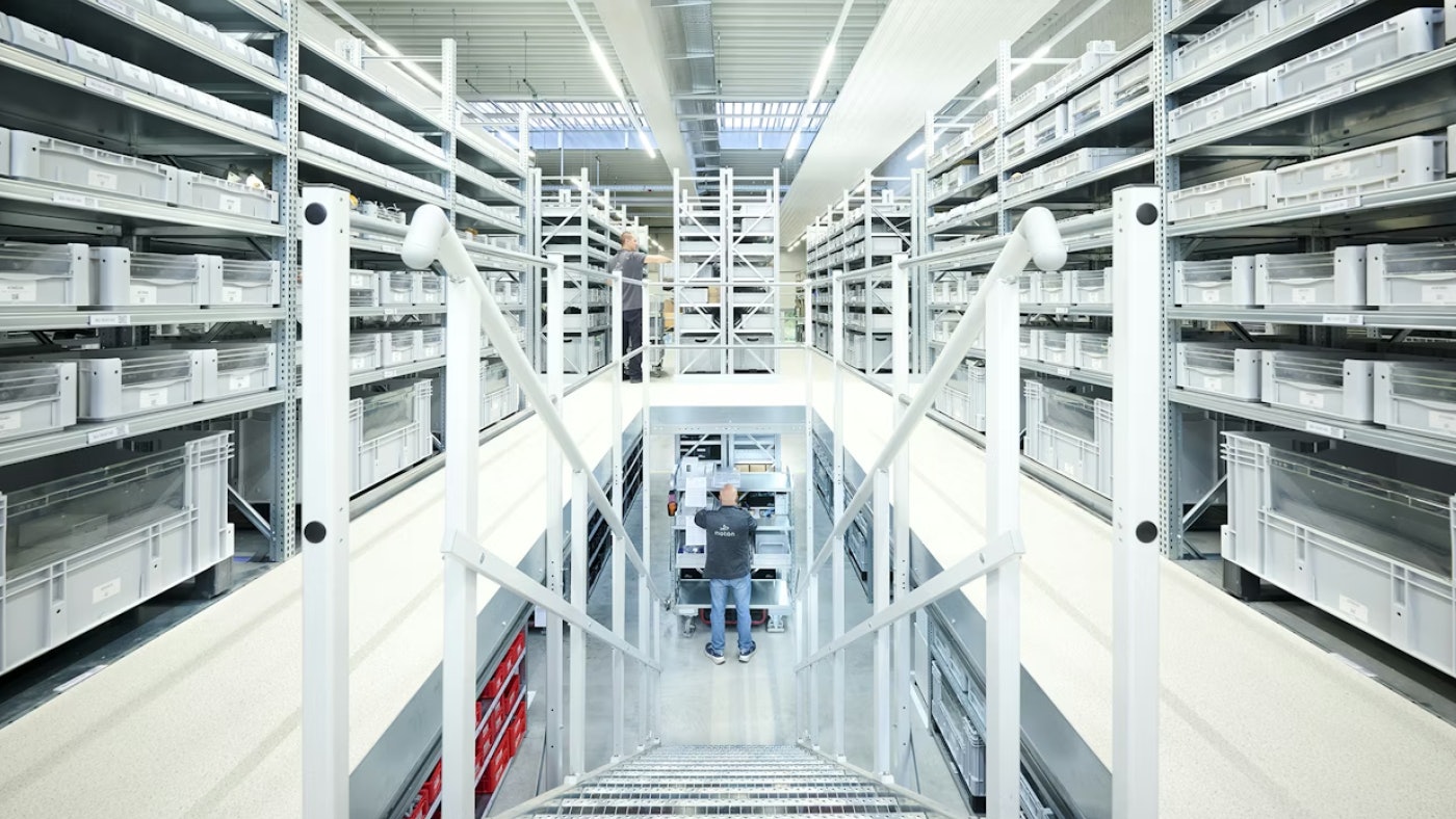 De foto toont de magazijnrekken op een eerste verdieping van een platformsysteem en de toegangstrap.