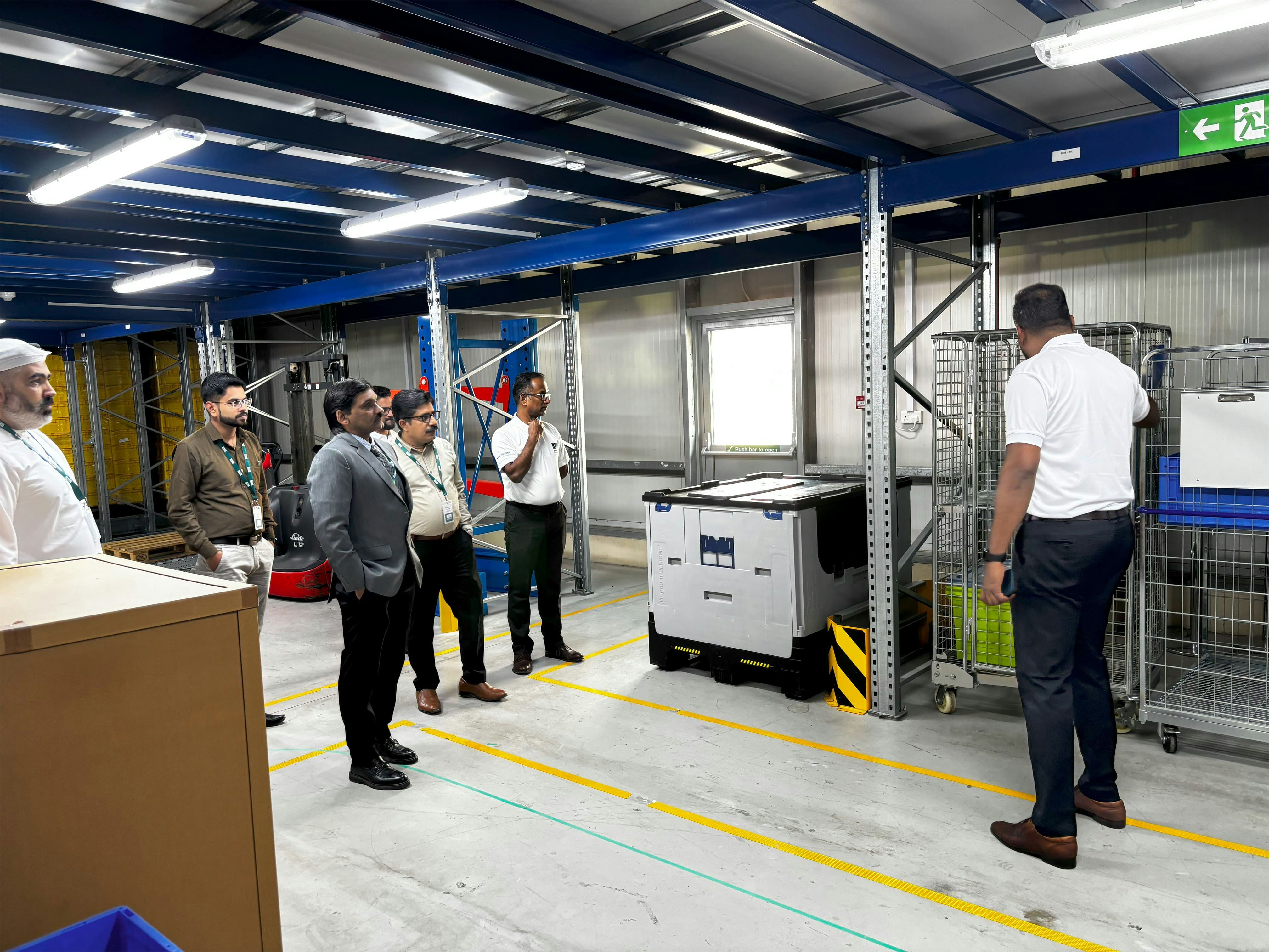 BITO ein Mitarbeiter zeigt einigen Besuchern einen Gitterwagen