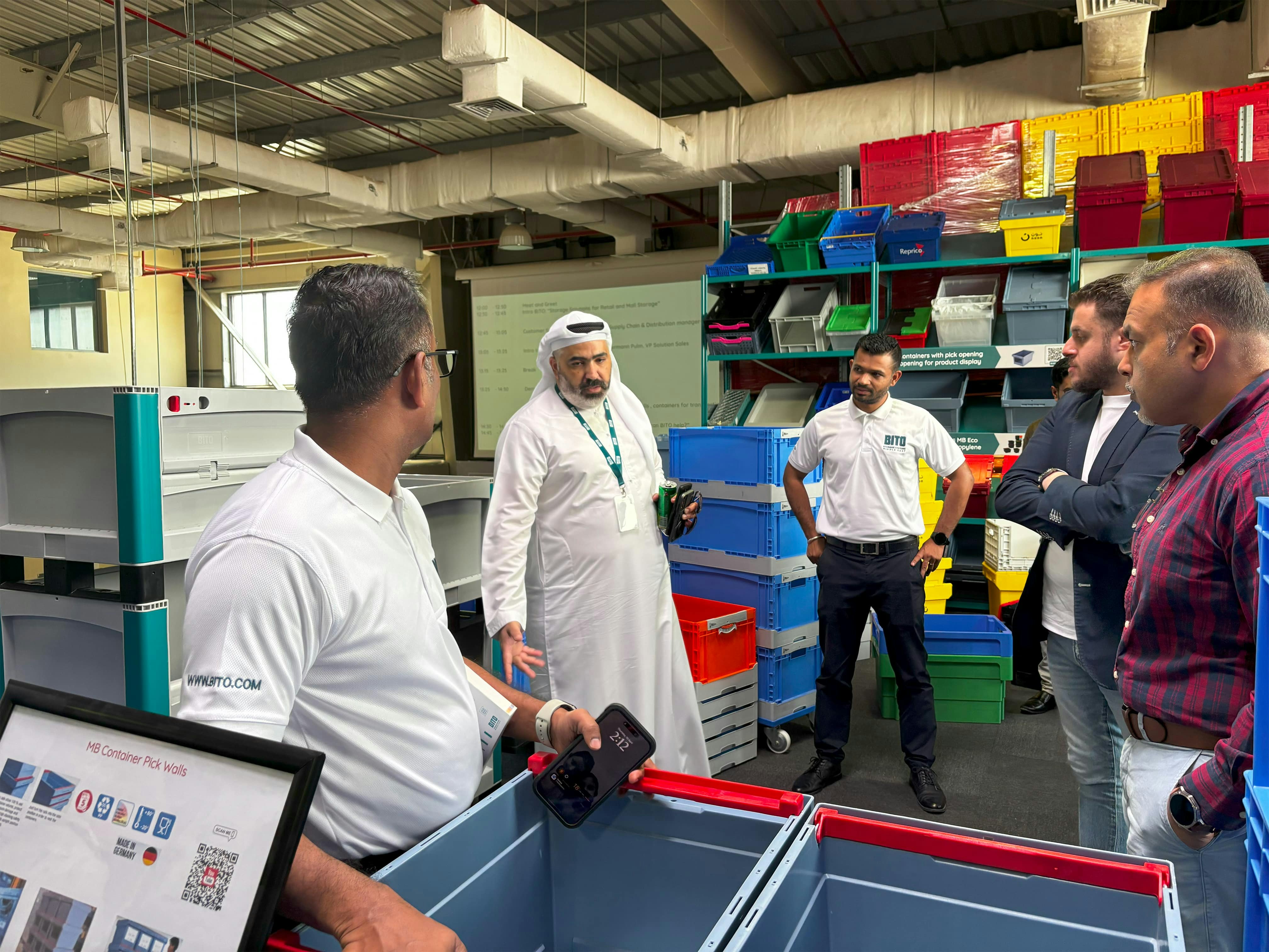 BITO Mitarbeiter und Besucher unterhalten sich über den Mehrwegbehälter MB von BITO