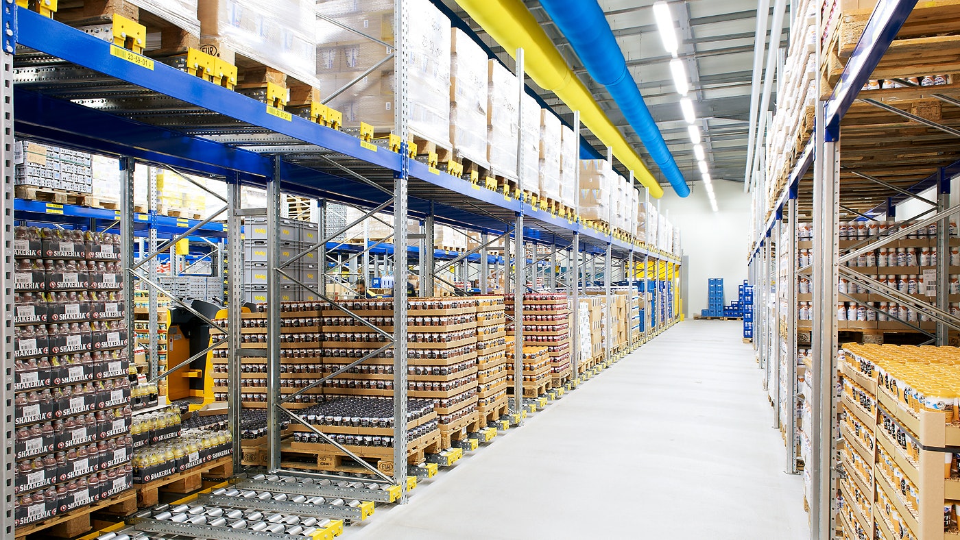 Magazijngang met palletstellingen en doorrolsysteem.