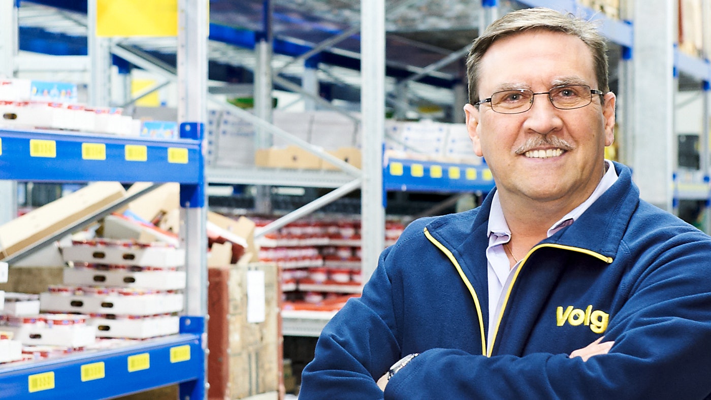 Magazijn vertantwoordelijke van Volg toont staat trots voor BITO magazijnrekken.