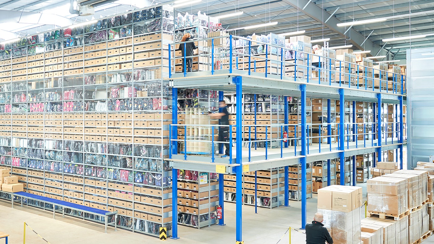 De foto laat legbordstellingen zien die in meerdere niveaus zijn opgebouwd in een magazijn.