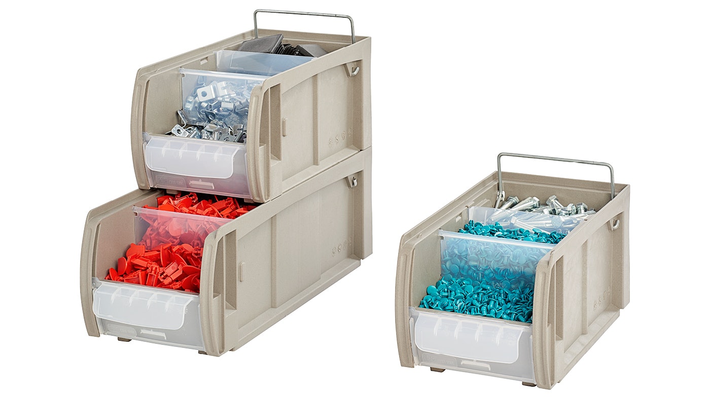 De foto toont gestapelde magazijnbakjes met kleine onderdelen. De bak is gemaakt uit zonnebloempitten.