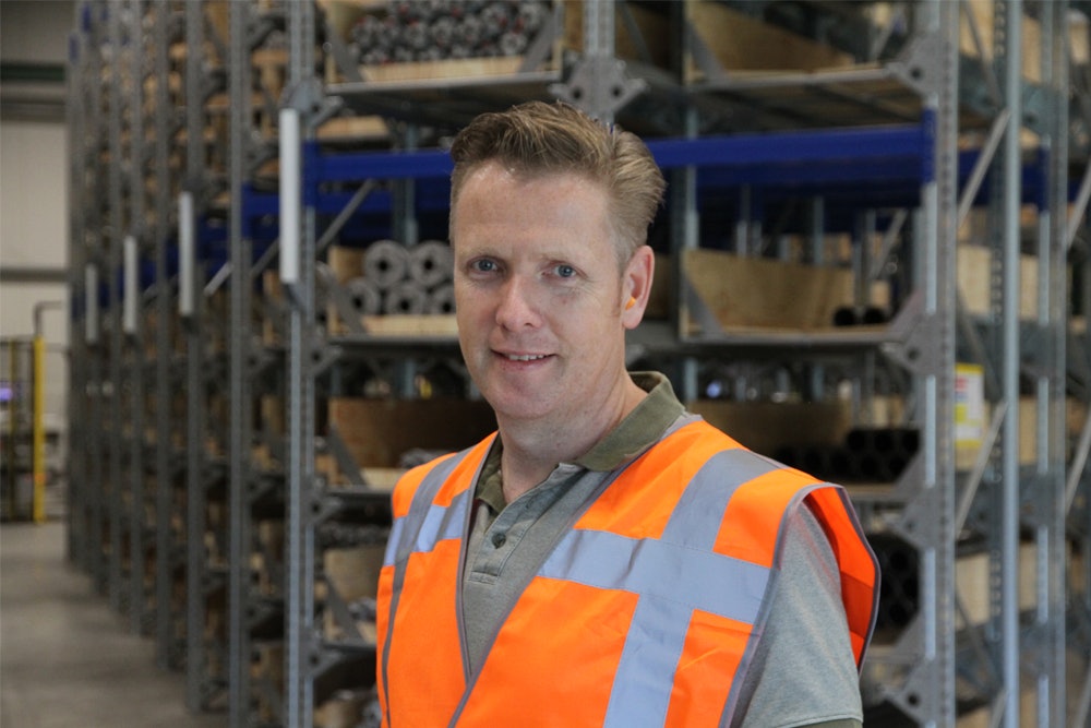 De foto toont een tevreden magazijnverantwoordelijke bij ConDoor