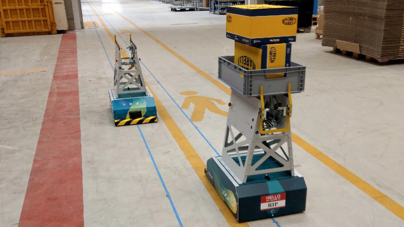 Automatisch geleid voertuig rijdt met de voorraad naar montagelijn