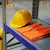 Yellow helmet and orange vest on shelf