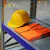 Yellow helmet and orange vest on shelf