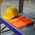 Yellow helmet and orange vest on shelf