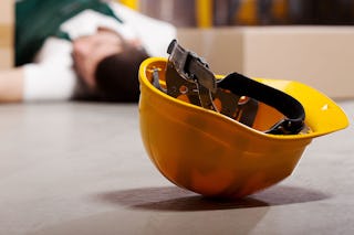 Ein Helm, im Hintergrund liegt ein Mann