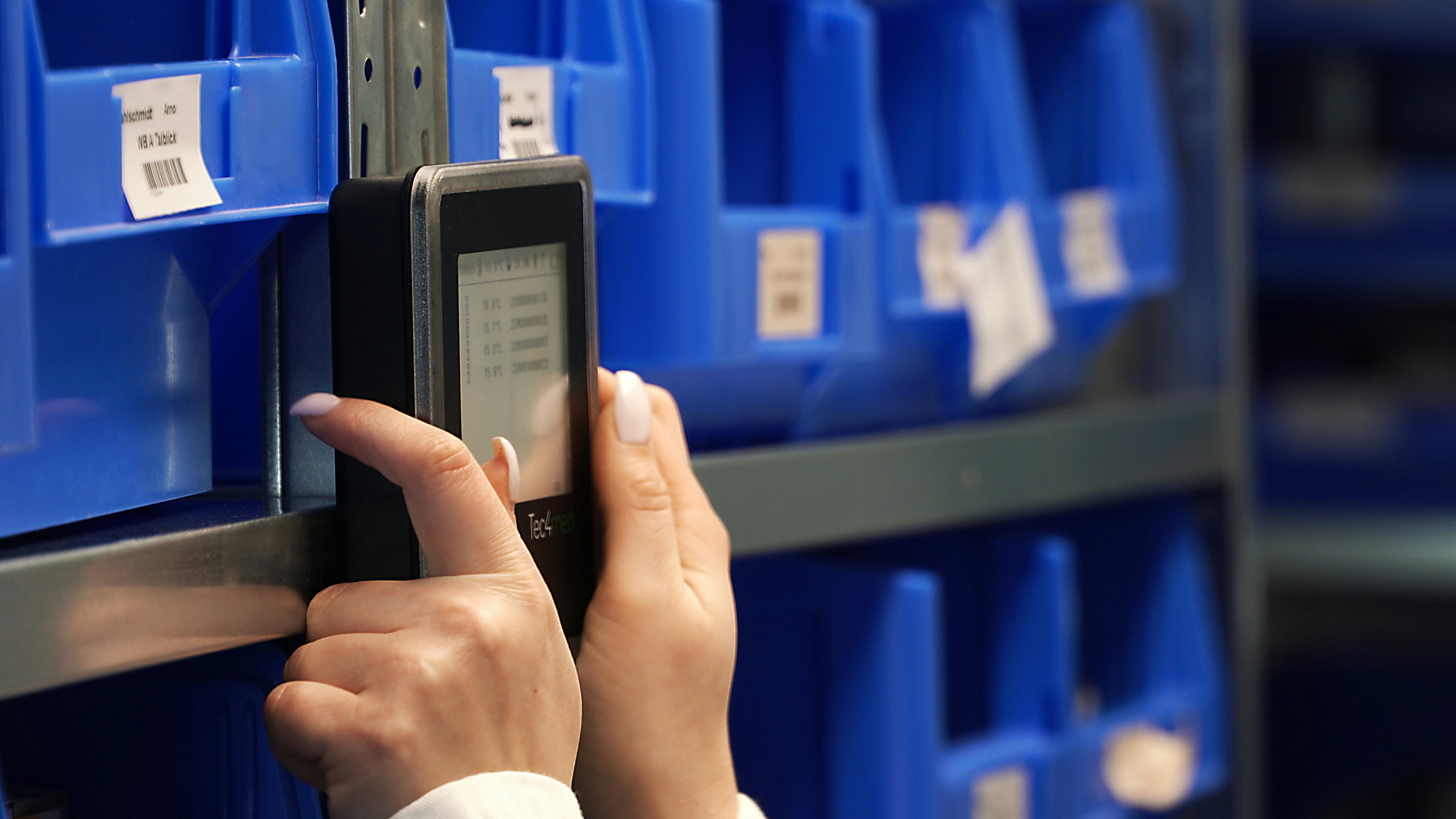 Eine Frau bringt einen SmartHub an einem Regal an