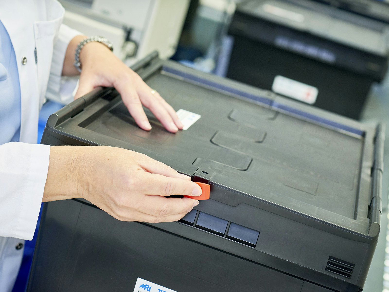 Eine Frau verplombt einen Mehrwegbehälter