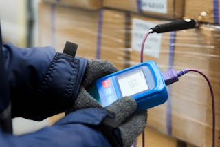 Mitarbeiter kontrolliert die Temperatur in einem Kühllager