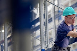 Ein Mann bei der Instanthaltung von einem Lageregal