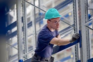 Ein Mann bei der Instanthaltung von einem Lageregal