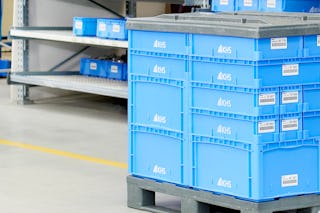 Verschieden große Behälter sauber auf einer Palette gestapelt.