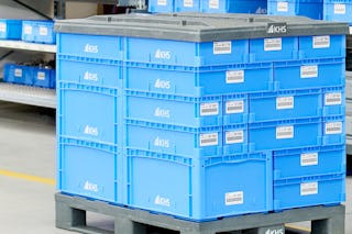 Verschieden große Behälter sauber auf einer Palette gestapelt.