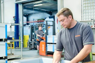 Zwei Männer bei der Arbeit. Daneben stehen Schwerlast SL Behälter von BITO.